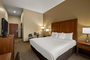 a hotel room with a bed and a flat screen tv at Comfort Inn Ogden near Event Center in Ogden