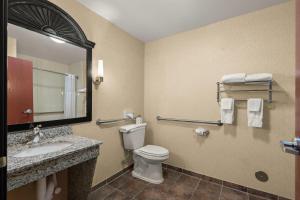 a bathroom with a toilet and a sink and a mirror at Comfort Inn Ogden near Event Center in Ogden +69 photos