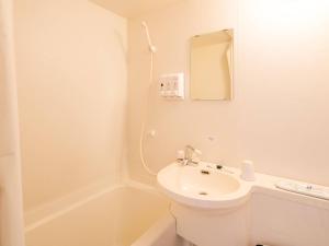 a white bathroom with a sink and a mirror at Comfort Inn Omihachiman in Omihachiman