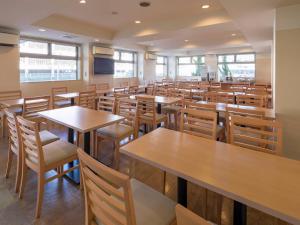 an empty restaurant with wooden tables and chairs at Comfort Inn Omihachiman in Omihachiman +17 photos