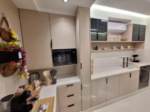 a kitchen with white cabinets and a washer and dryer at East Coast Vacation Homes in Kalbā