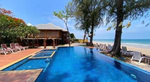 a large blue swimming pool next to a beach at Baan Talay Dao Resort in Hua Hin