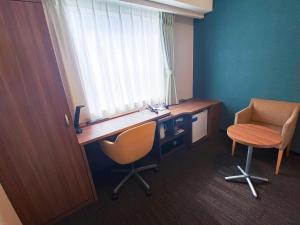 Una oficina con un escritorio y una silla y una ventana. en Comfort Hotel Sapporo Susukino, en Sapporo