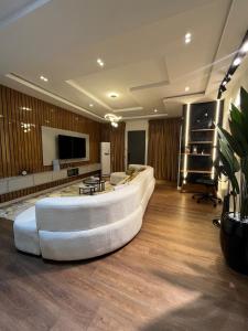 Una sala de estar con un sofá blanco y un televisor. en Lisa apartment, en Kadobunkuro 3 fotos más