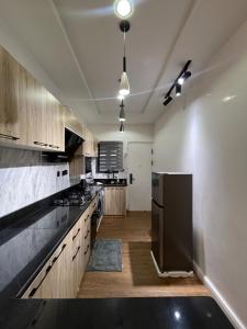 Una cocina con gabinetes de madera y un refrigerador negro. en Lisa apartment, en Kadobunkuro