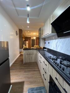 Una cocina con gabinetes de madera y un horno de estufa. en Lisa apartment, en Kadobunkuro