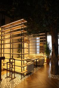 タシュケントにあるAzimut Hotel Tashkentのソファとテーブルと木のある部屋