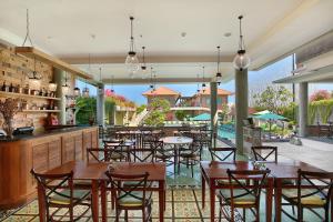 a restaurant with tables and chairs and a pool at Maison at C Boutique Hotel & Spa Seminyak in Seminyak