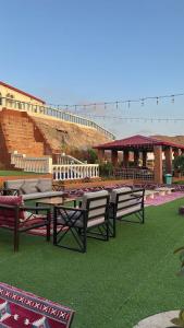 Difta resort : مجموعة من المقاعد والطاولات على العشب