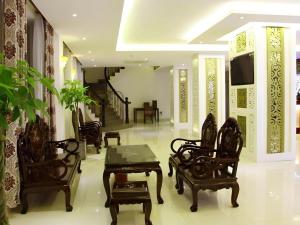 a living room with chairs and a table and a tv at Rain Bow Hotel in Ho Chi Minh City +31 photos