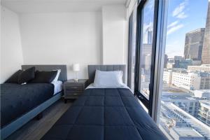 ロサンゼルスにあるThe Olive Skyline 2 Bed Apt with FREE PARKING in DTLAのベッドと大きな窓のある寝室 +79枚の写真