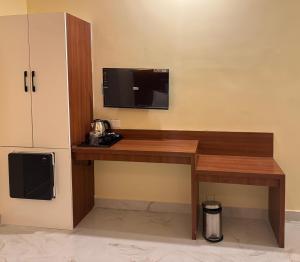 a desk in a room with a tv on a wall at Road House Resort in Rāmeswaram
