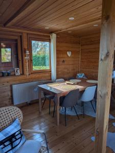 een eetkamer met een tafel en stoelen in een hut bij Holzhaus in Langatte +38 foto's