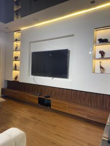 a living room with a large flat screen tv on a wall at Estelle Service Apartments Limited in Ikate +6 photos