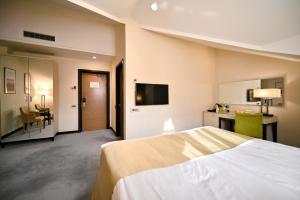 a hotel room with a large bed and a desk at Ararat Resort Tsaghkadzor in Tsaghkadzor