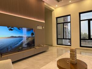 a living room with a large flat screen tv at H chalet in ‘Uqdah