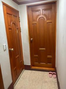 a pair of pink slippers standing in front of a door at Seven Motel in Busan