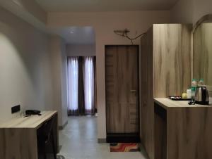 a room with a kitchen with a wooden door at Hotel City View in Golāghāt