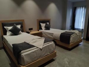 two beds in a hotel room withskirts at Hotel City View in Golāghāt