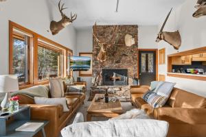 RMR: Stock House in Teton Village في قرية تيتون: غرفة معيشة مع أثاث من الجلد ومدفأة حجرية