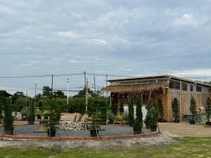 une serre avec des plantes en pot devant un bâtiment dans l'établissement LeLaNa Farmstay Camping, à Pak Chong