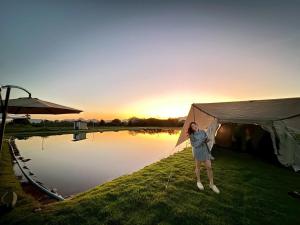 une femme debout près d'une tente au bord d'un lac dans l'établissement LeLaNa Farmstay Camping, à Pak Chong 55 autres photos