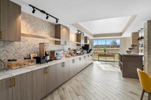 コンウェイにあるComfort Suites Conwayの大きなキッチン(木製キャビネット付)、大きな窓が備わります。