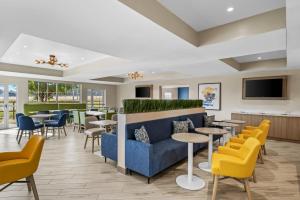 コンウェイにあるComfort Suites Conwayの黄色の椅子とテーブル、青いソファのあるレストラン