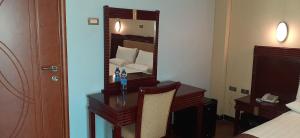 Abay international Hotel في بحر دار: غرفة بها مكتب وسرير ومرآة