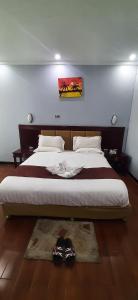 Abay international Hotel في بحر دار: غرفة نوم بسرير كبير عليها حذاء