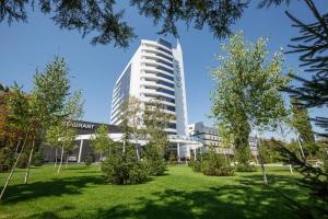 a tall building with a park in front of it at Atlantic Garden Resort in Odesa