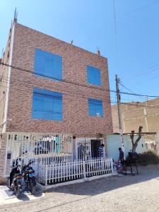 een bakstenen gebouw met twee motorfietsen ervoor geparkeerd bij Hospedaje Kaiak in Pacasmayo