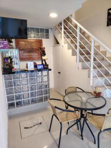 een eetkamer met een tafel en stoelen en een trap bij Hospedaje Kaiak in Pacasmayo