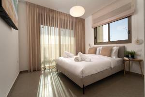 a bedroom with a large bed and a large window at DreamyRent Aqua Sol Eilat in Eilat +16 photos
