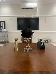 a living room with a wooden table and a television at Big studio apartment in Makkah