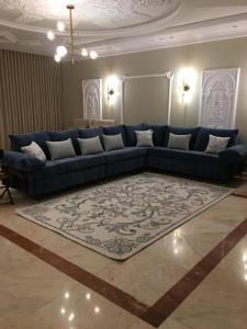 a living room with a blue couch and a rug at Big studio apartment in Makkah