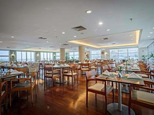 a dining room with tables and chairs in a restaurant at Mercure Salvador Rio Vermelho in Salvador