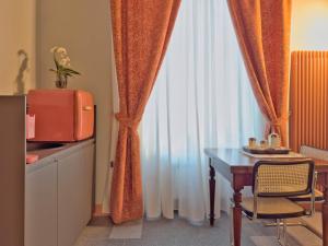 una camera con tavolo e finestra con tende di Cinisca Suite Blue a Bologna Altre 5 foto