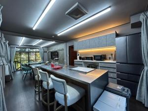 Ogiファミーユ 一碧湖 湖近く 温泉 屋根付バーベキューテラス 1棟貸切宿的厨房里有一个带吧台凳的大岛台