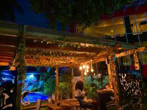a woman sitting at a table in a patio at night at The Executive Suite in Lagos