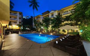 a swimming pool in front of a building at night at Sandalwood Hotel & Suites in Panaji