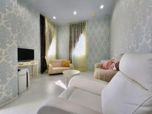 一棟貸しゲストハウス マリドール في إزومو: غرفة معيشة مع أريكة وتلفزيون