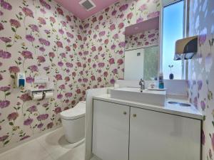 一棟貸しゲストハウス マリドール في إزومو: حمام مع حوض ومرحاض وزهور +105 صور