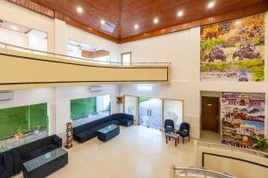 een woonkamer met een bank en een trap bij Nature Trails Chilla, Rishikesh in Rāiwāla