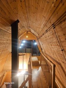 una camera con soffitto in legno e scala di twin cottages a Goderdzi Altre 12 foto