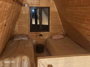due letti in una piccola stanza con una finestra di twin cottages a Goderdzi