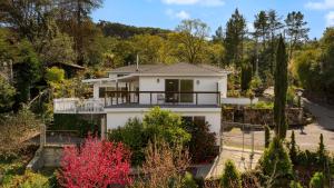 ein weißes Haus mit einem Balkon und Bäumen in der Unterkunft Modern Sonoma Stay w Spacious Deck Views Prime Location Bennett in Santa Rosa