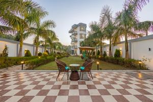 een patio met stoelen en een tafel voor een gebouw bij Nature Trails Chilla, Rishikesh in Rāiwāla