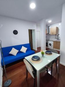 ein Wohnzimmer mit einem blauen Sofa und einem Tisch in der Unterkunft Benimaclet JTM in Valencia