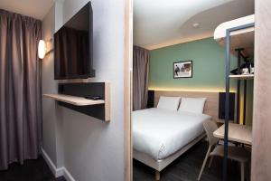 a hotel room with a bed and a desk at Kyriad Anglet - Biarritz in Anglet +55 photos
